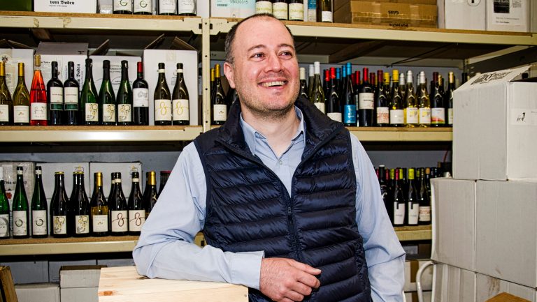 Luke Wohler poses in wine warehouse
