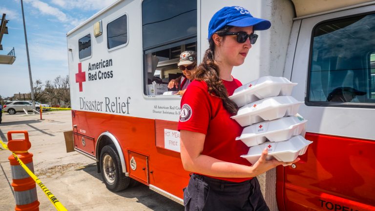 FEMA member taking meals from an emergency response vehicle