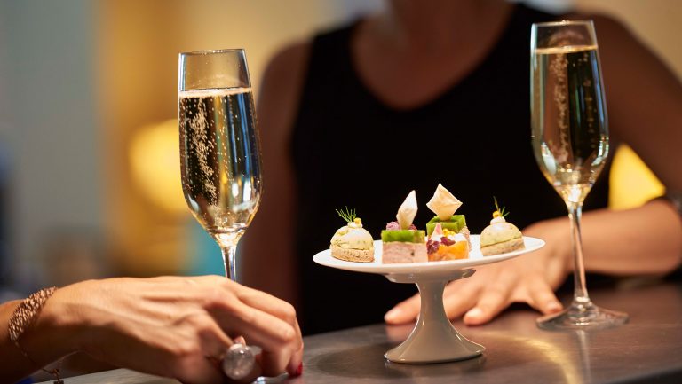 Two glasses of Bourgogne Crémant complemented by a plate of hors d'oeuvres