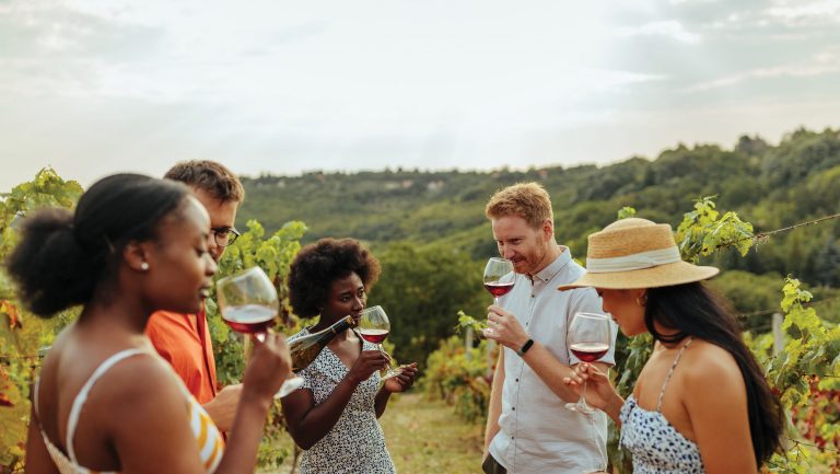 A group of people participate in a wine tasting outdoors