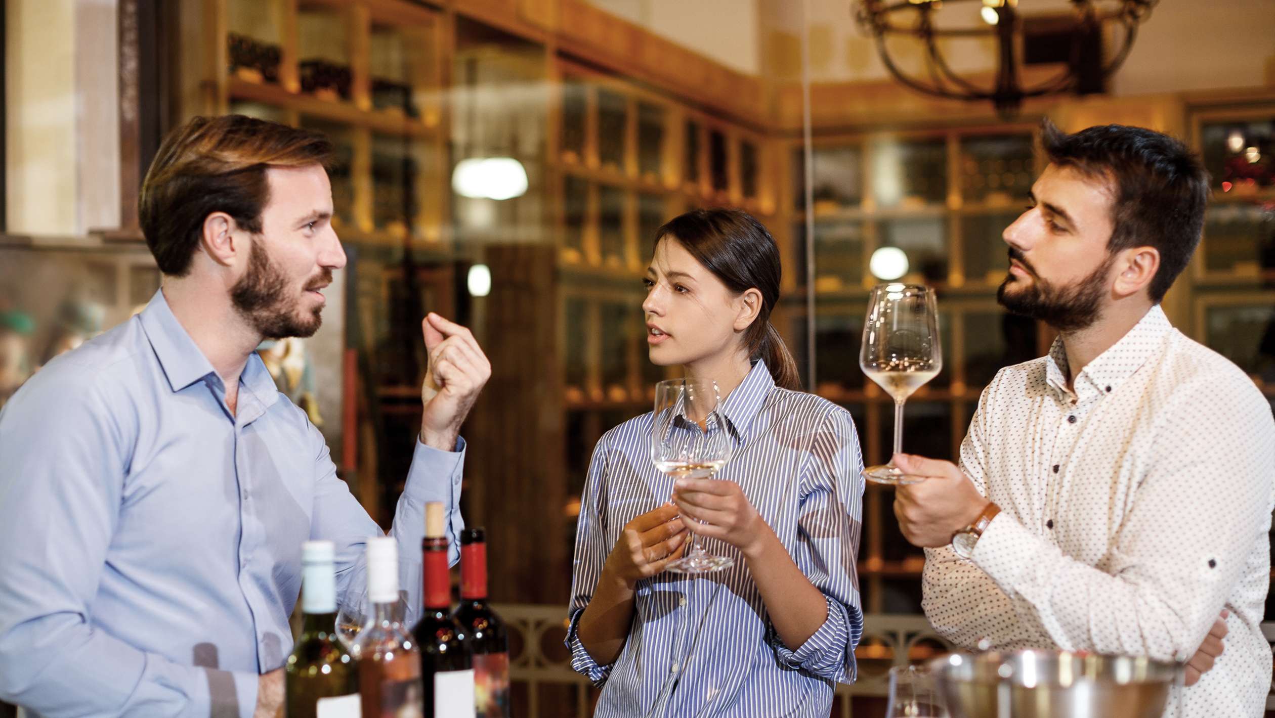 Three professionals discuss a selection of wines