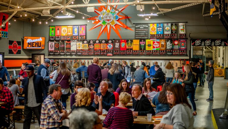 An interior photo of a crowded Sun King Brewing taproom