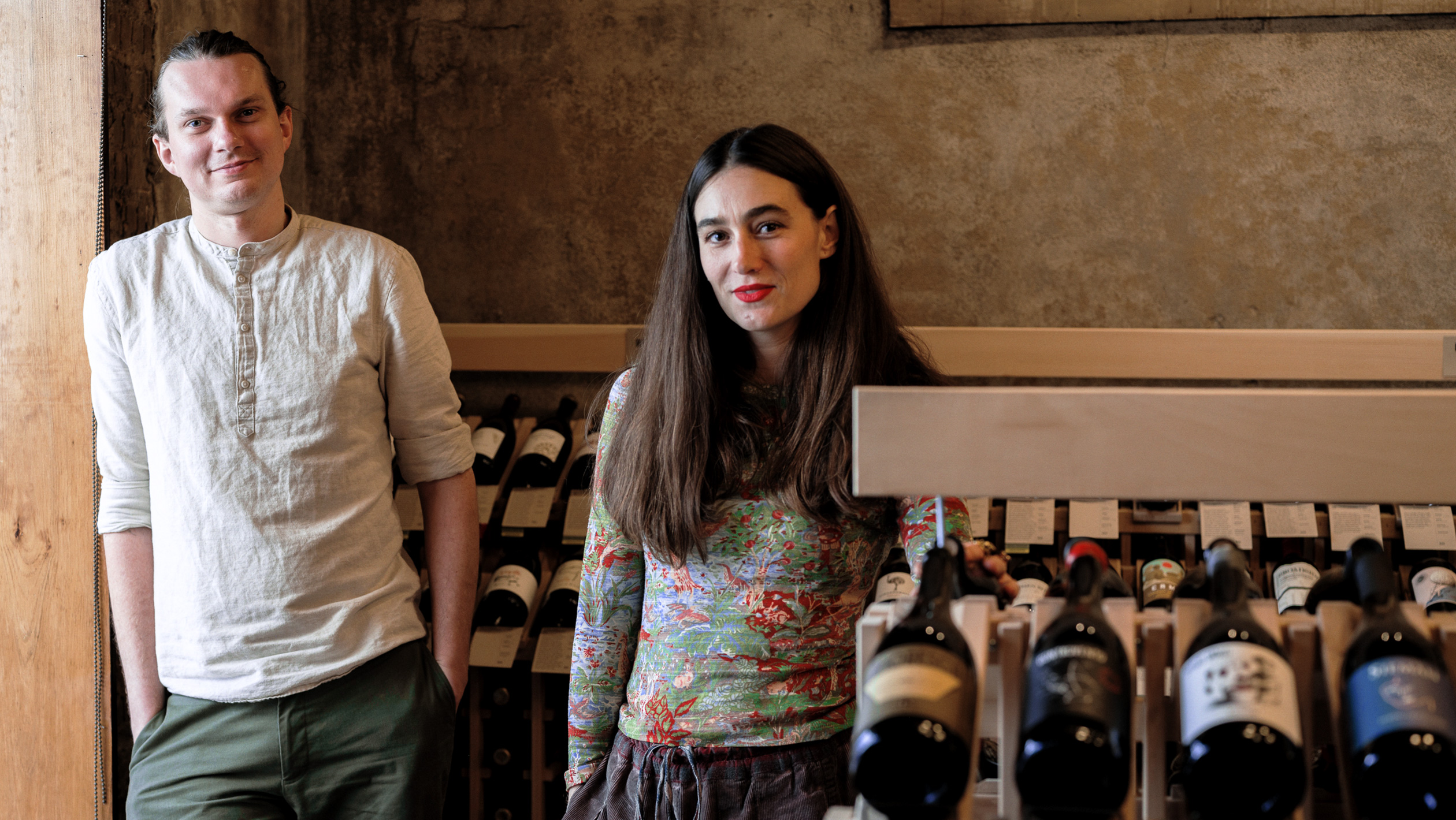 Jonas Andersen and Natalie Marie Gehrels, co-owners of Folkways, pose in their shop in front of shelves of wine