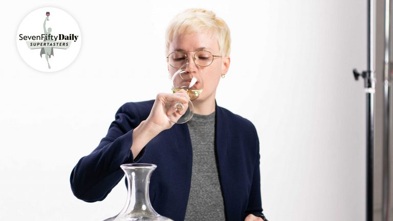 Marie Cheslik sips a white wine in a studio