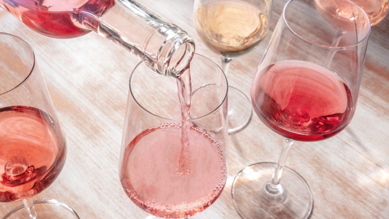 A group of glasses of different rosé wines, each varying in color