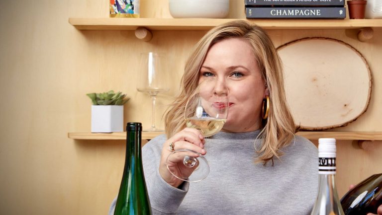 A headshot of Amy Waller sipping a German Riesling