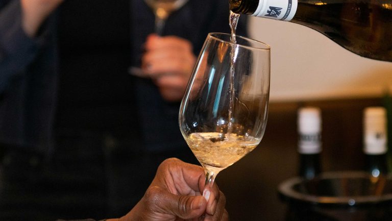 A white German wine is poured into a glass at a tasting event