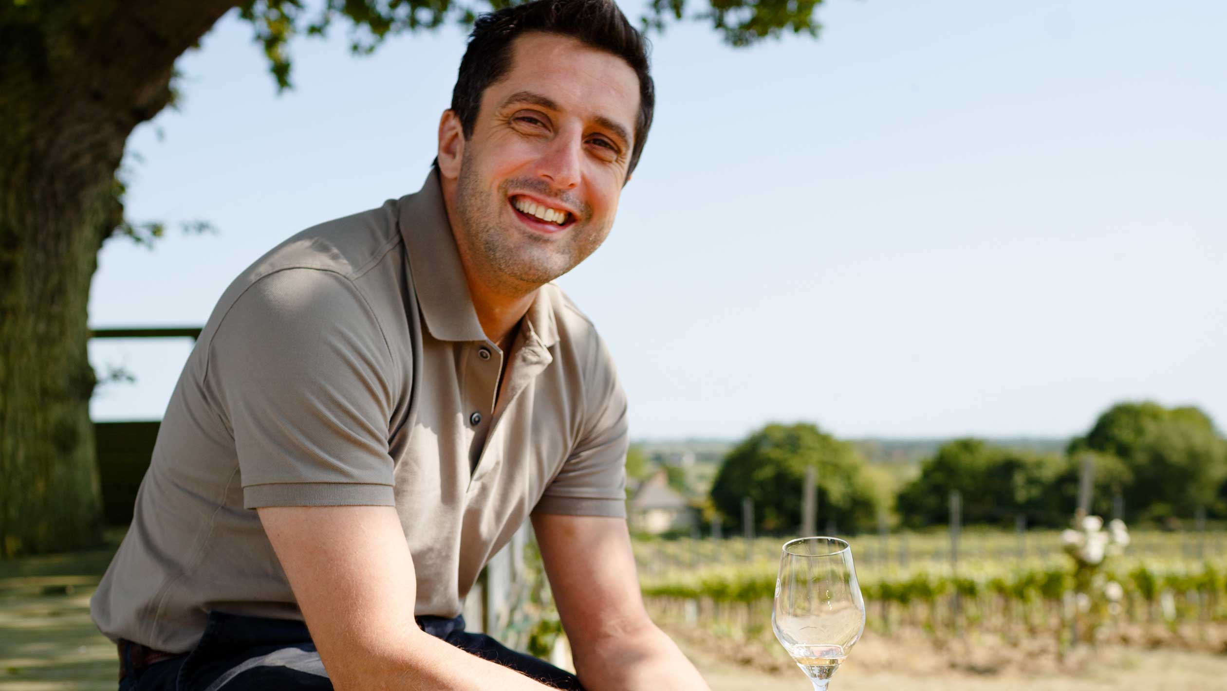 A headshot of Charlie Holland outside of a vineyard