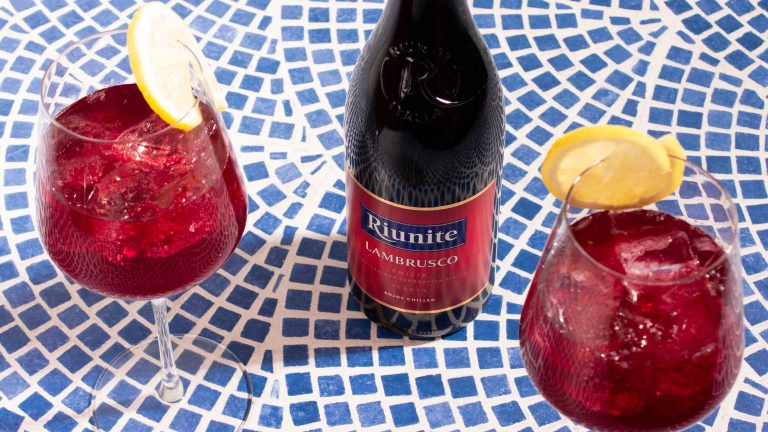 A bottle of Riunite Lambrusco next to two cocktails