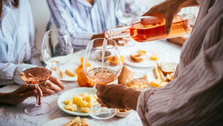 A table set with food and featuring glasses of rosé