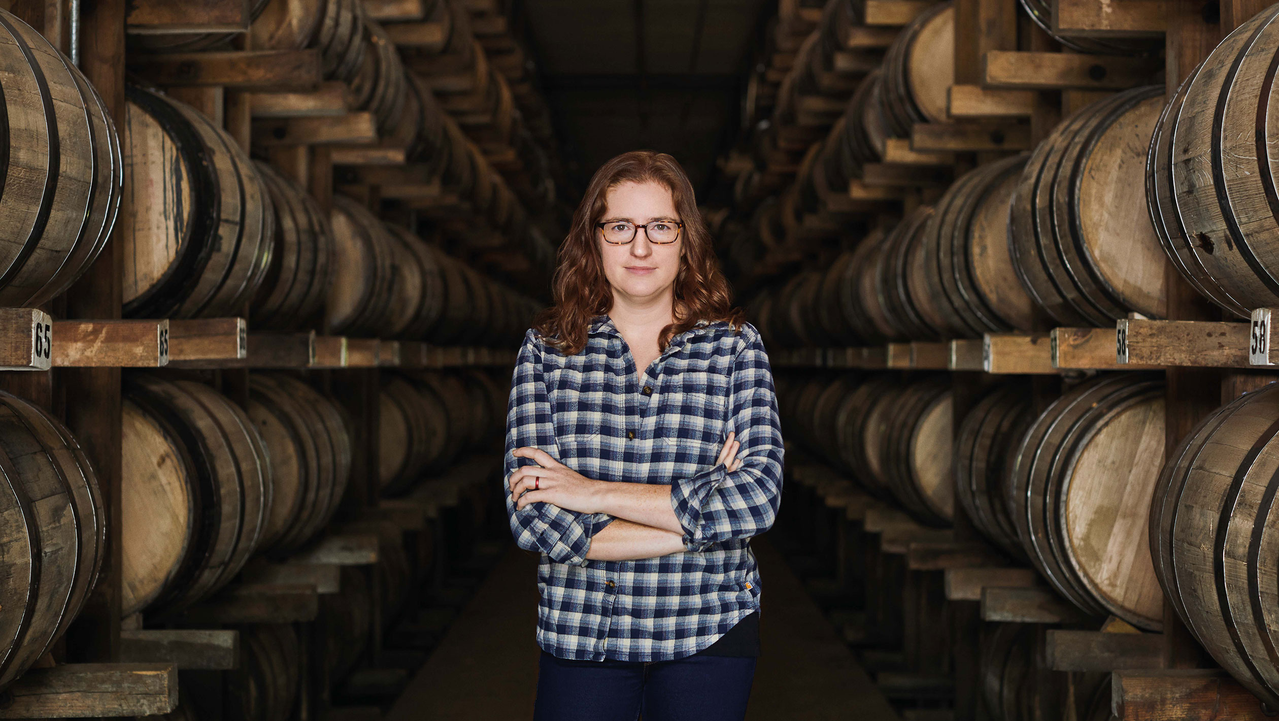 Headshot of Nicole Austin amongst Cascade Hollow Distillery barrels.