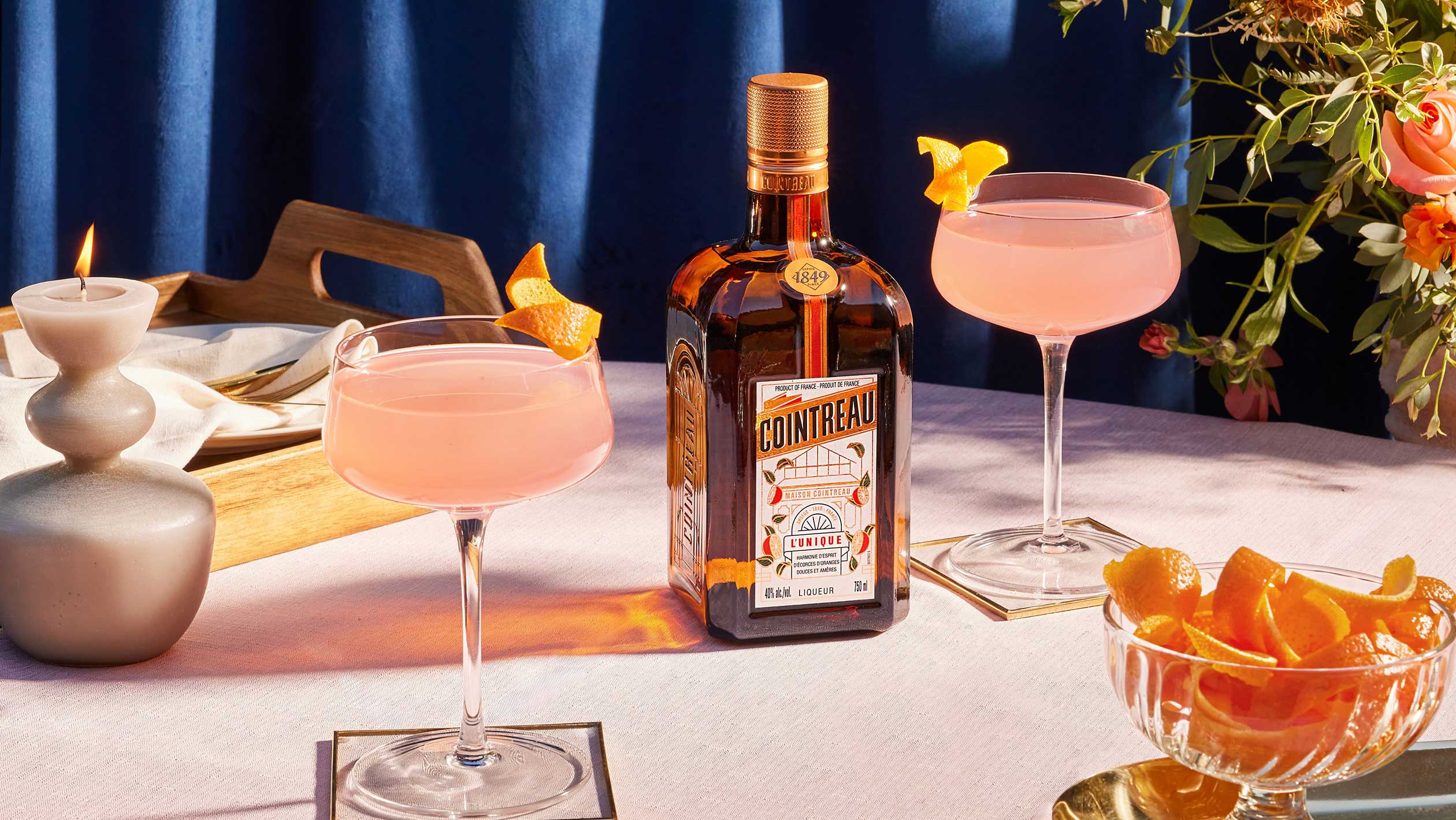 A bottle of Cointreau surrounded by festive cocktails