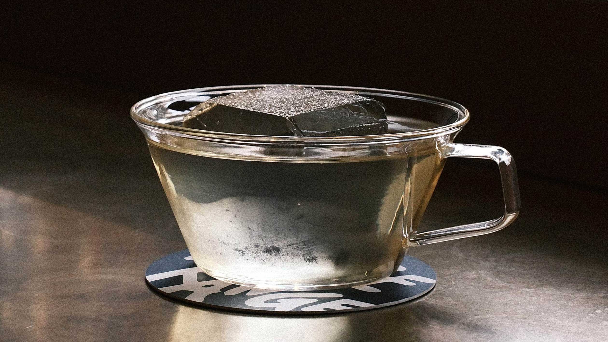 A clear cocktail in a glass shaped like a teacup