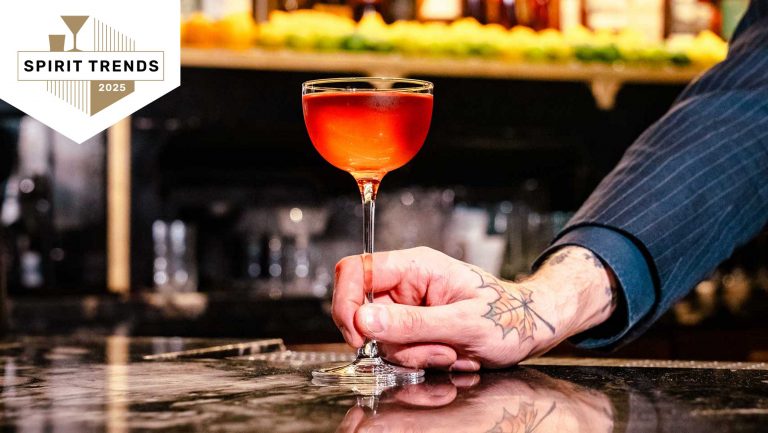 A close up of a hand holding a cocktail