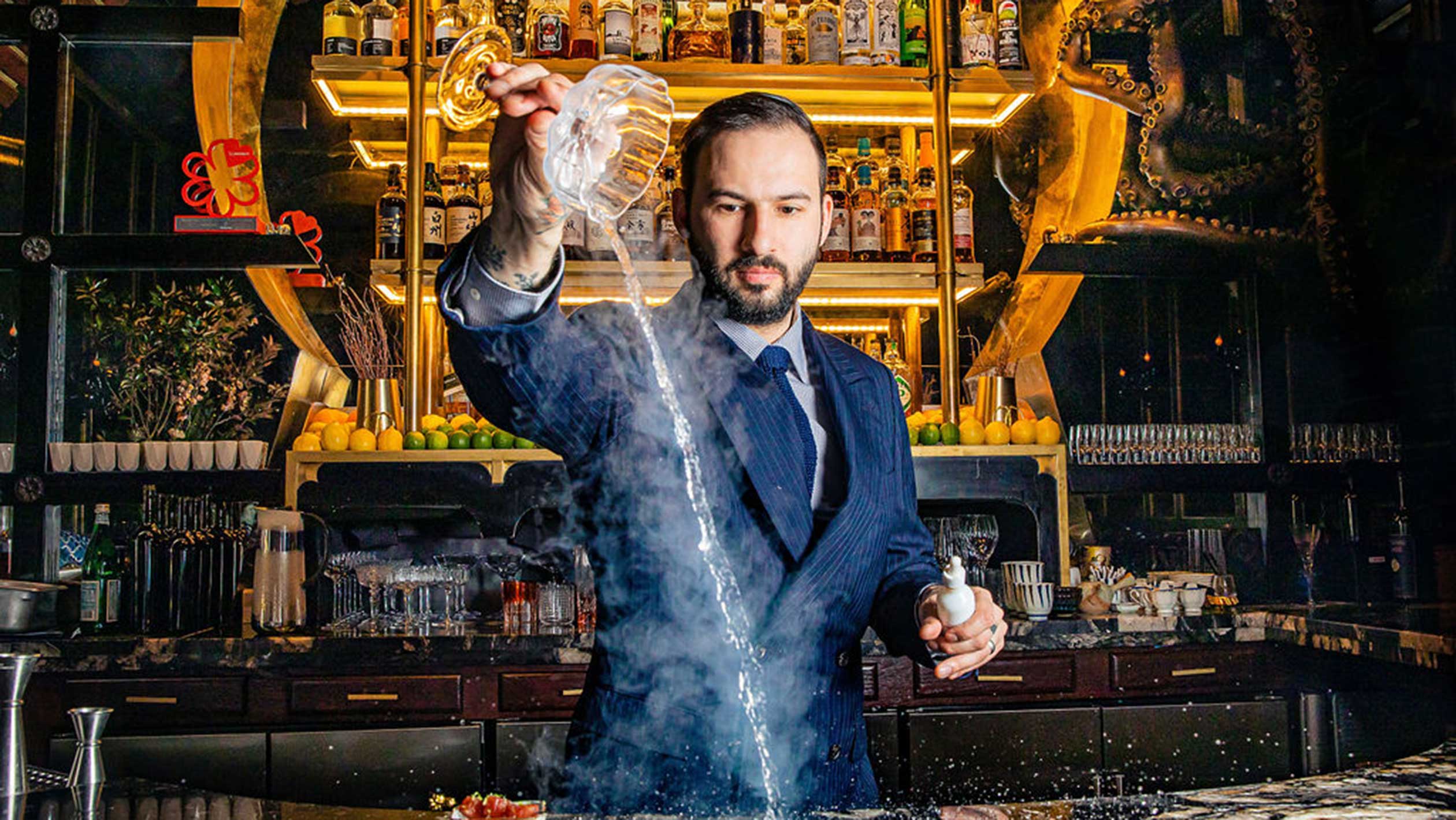 Photo of Jonathan Adler pouring a drink behind the bar at Shinji's.