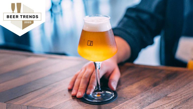 A closeup photo of a hand serving a glass of beer