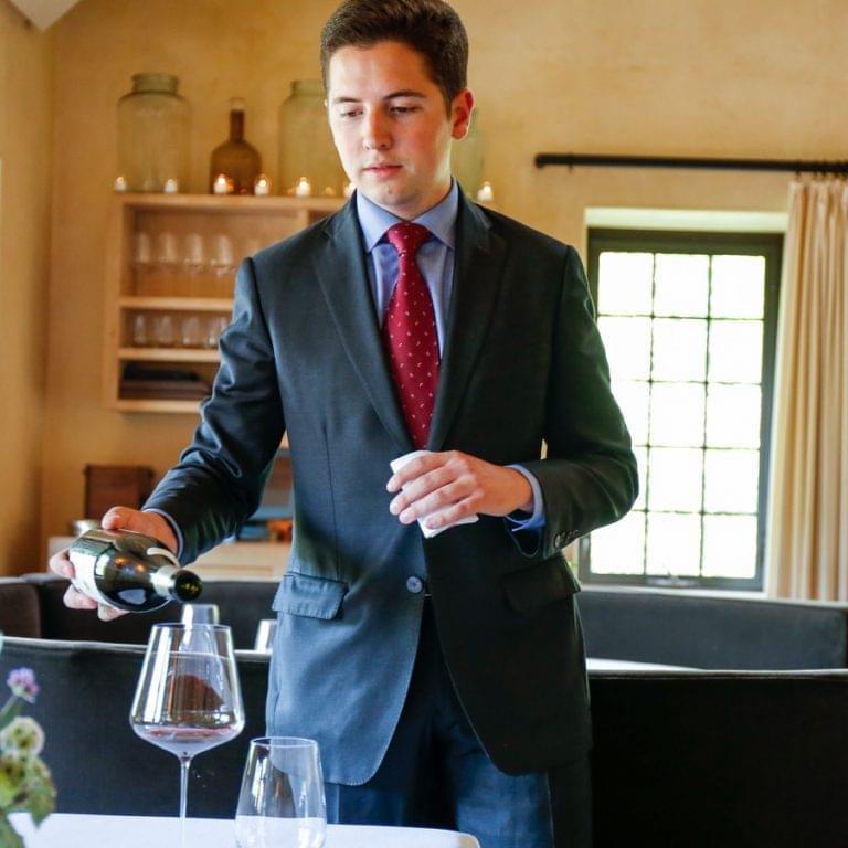 William Carroll pouring wine