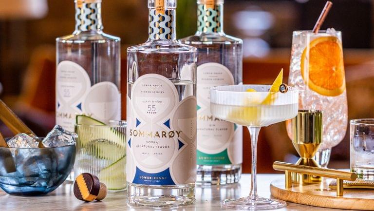 Closeup of a selection of Sommarøy bottles next to some cocktails