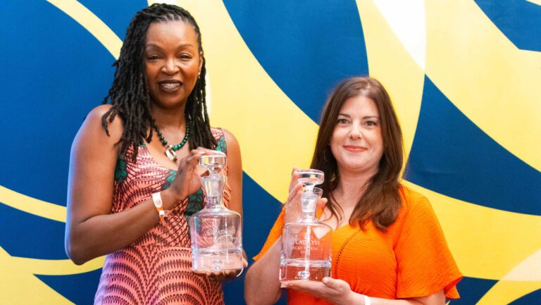 Keyatta Mincey-Parker and Becky Paskin pose with their Tales Catalyst awards which are presented in the form of crystal decanters