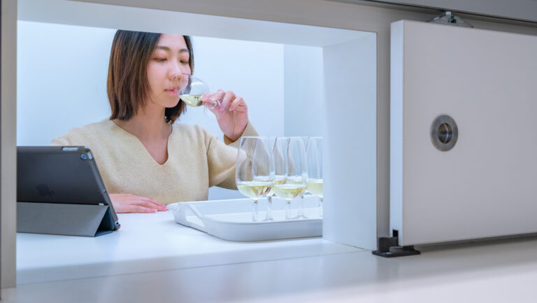 A woman tasting several samples of Riesling wines.