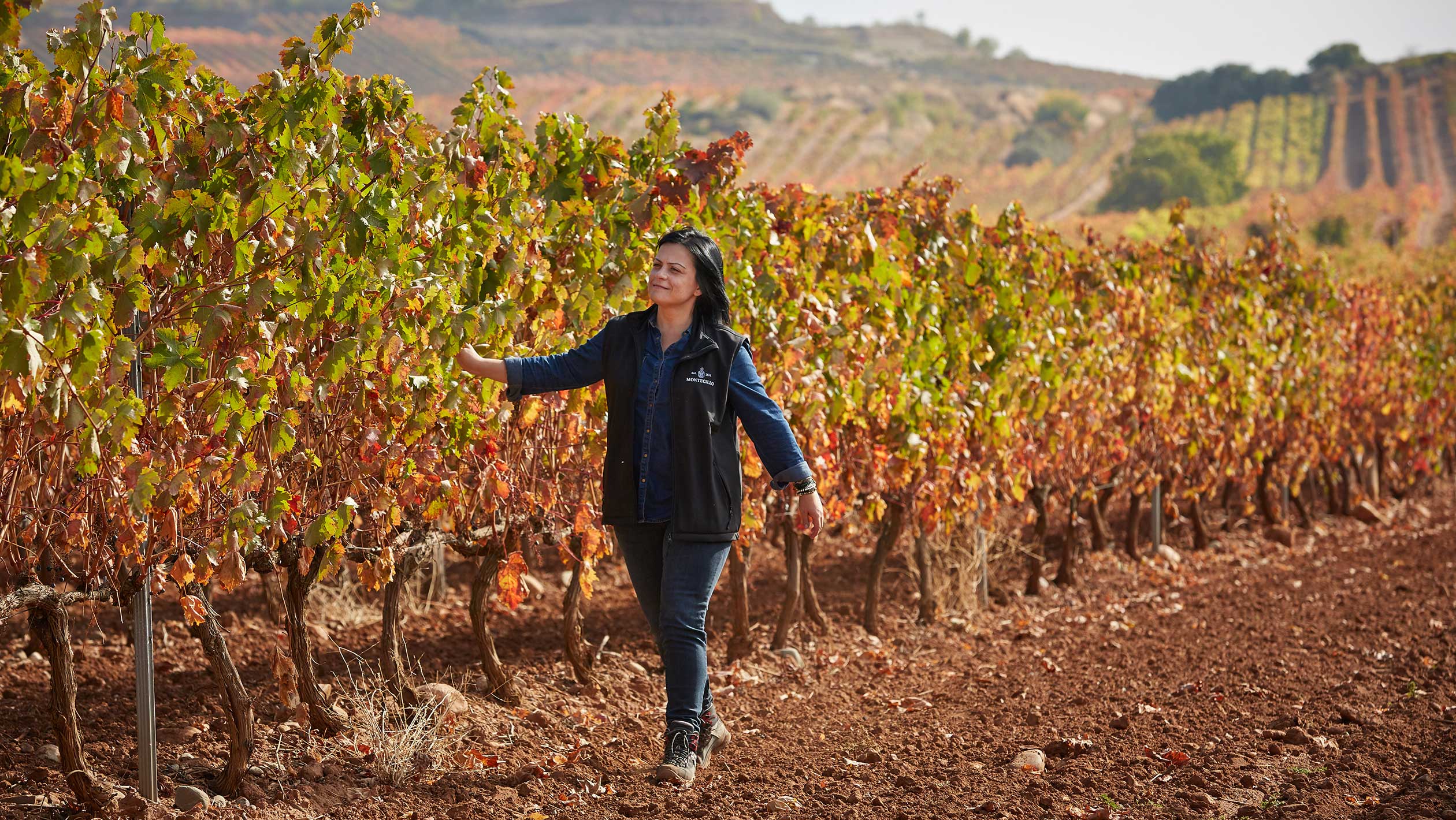 A photo of Mercedes García Rupérez walking through a vineyard.