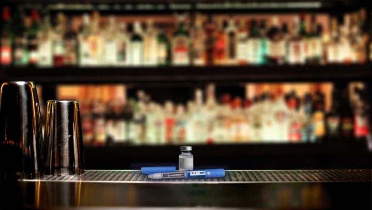 Materials for an Ozempic dose lie on a bartop with an out-of-focus barback in the background.