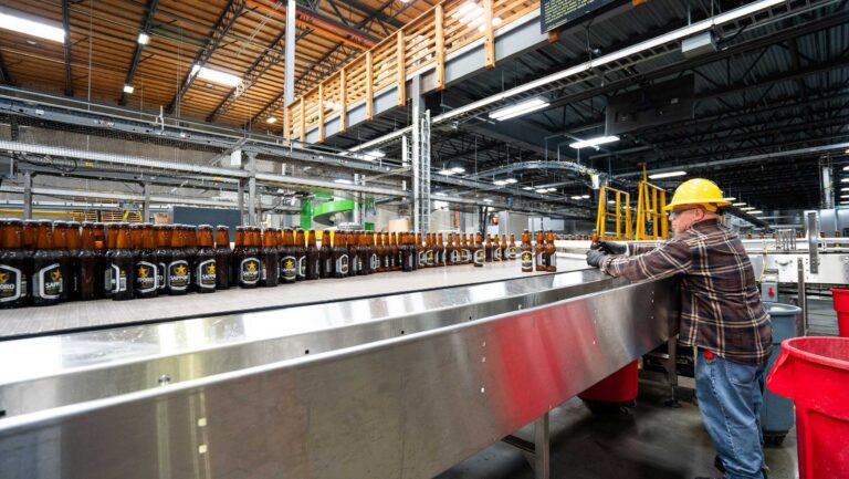 A man standing in the pack hall of the brewery.