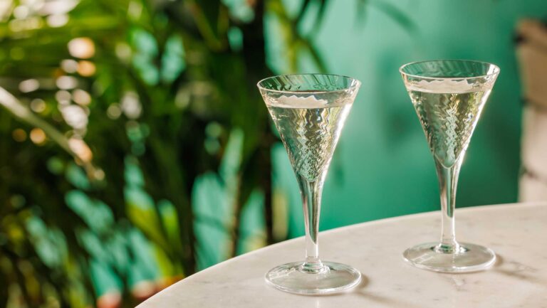Two tiny cocktails against a green background.