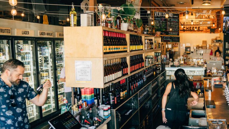 As margins tighten, bottle shops add food, draft beer, and community events to stay relevant. Photo of Bottlecraft by Andre J Bick Media.