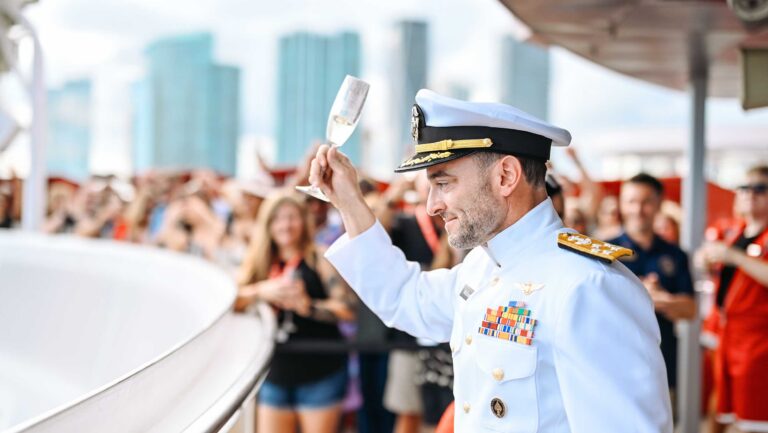 Tim McEnery, the founder and CEO of Cooper’s Hawk Winery & Restaurant, dressed in a ship captain's uniform on the deck of the cruise ship Valiant Lady.